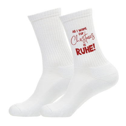 Freigestellte weiße Tennissocken mit dem roten Aufdruck ‚All I want for Christmas is RUHE!‘.