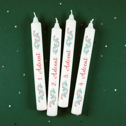 Vier Adventskerzen mit grün-rotem Zweigdesign und Adventszahlen auf grünem Hintergrund mit kleinen Sternen.