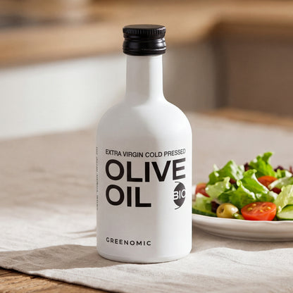 Greenomic Olivenöl in weißer Designerflasche mit Salat auf Holztisch dekoriert