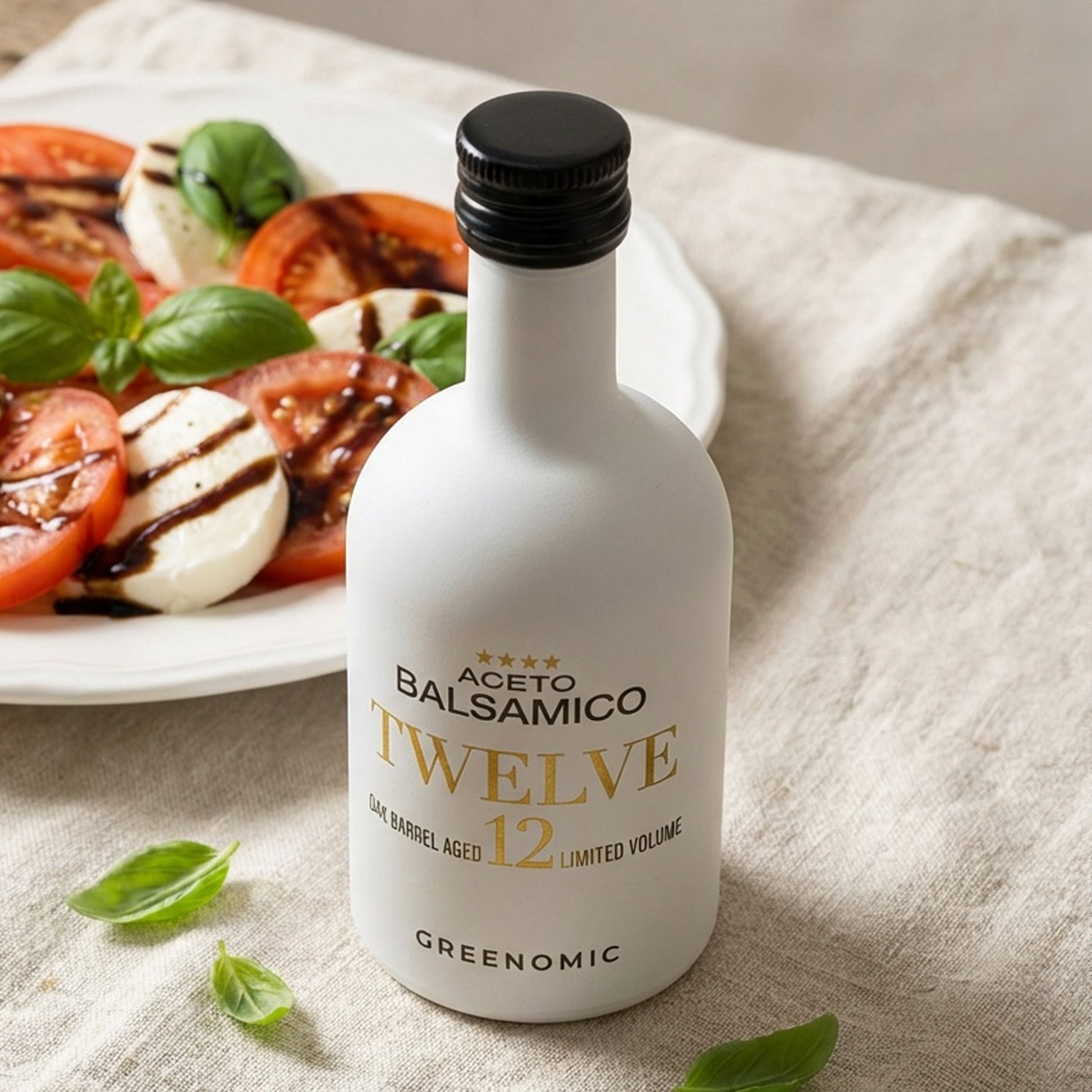 Greenomic Aceto Balsamico Twelve in weißer Designer Keramikflasche neben Tomate Mozzarella