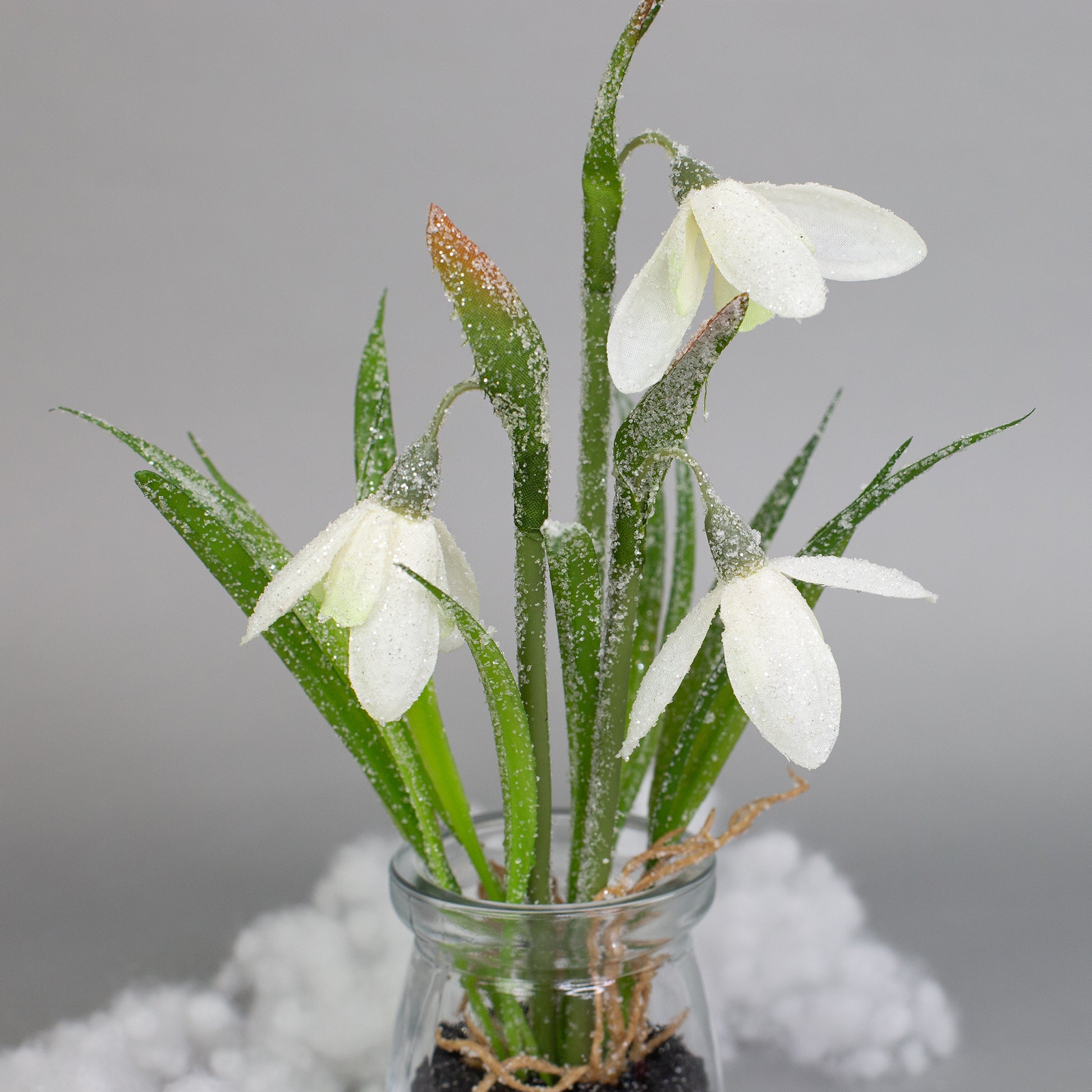 Detailansicht der Schneeglöckchenblüten aus Seidenblumen im Glasgefäß