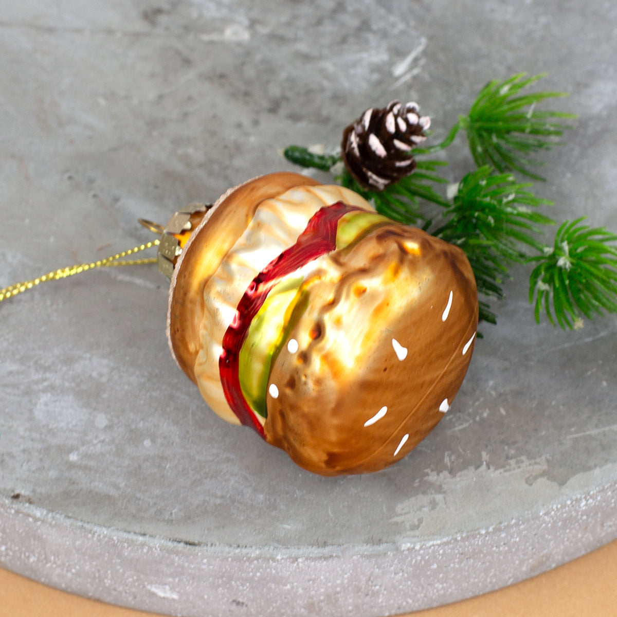Burger Weihnachtsbaumschmuck aus Glas mit Sesambrötchen und buntem Belag in Detailansicht