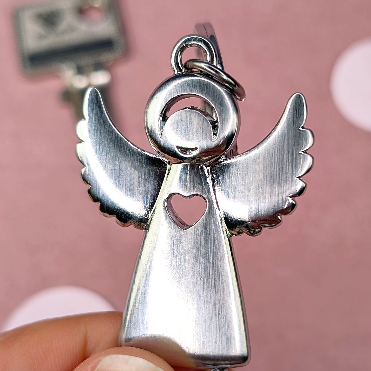 Detailaufnahme des silberfarbenen Metall-Engels mit Herz-Ausschnitt und strukturierter Oberfläche