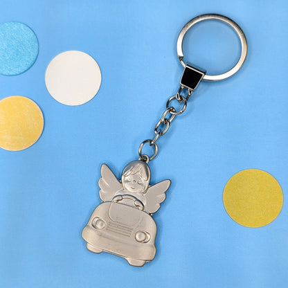 Schutzengel-Schlüsselanhänger im Auto mit Schlüsselring – frontal fotografiert auf blauem Hintergrund