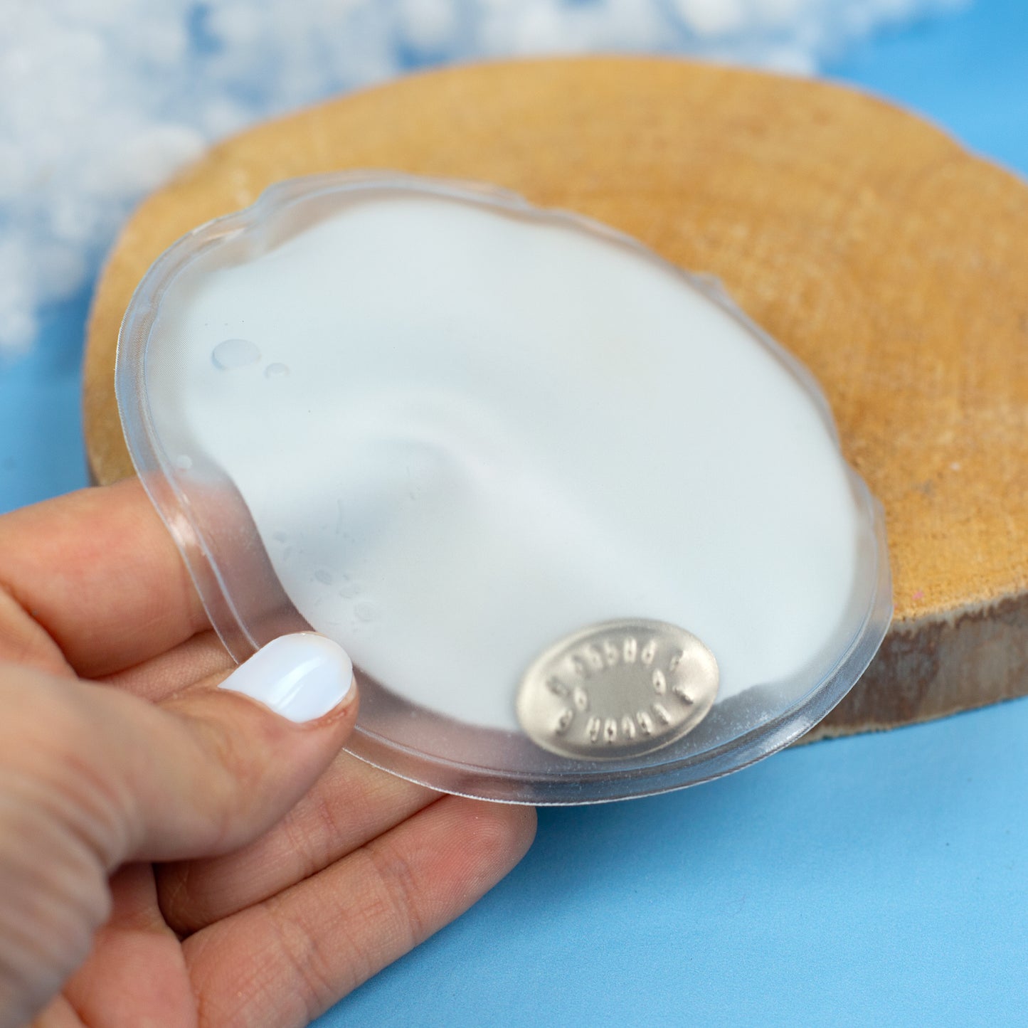 Rückseite des runden Handwärmers mit Metallplättchen in der Hand