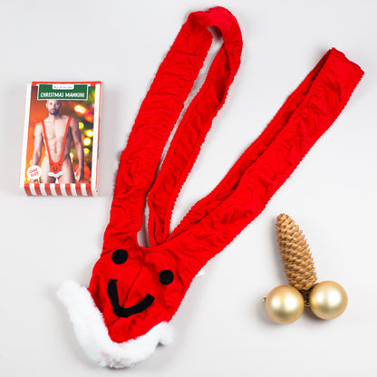 Roter Weihnachts-Mankini flach auf hellem Hintergrund, Verpackung daneben.