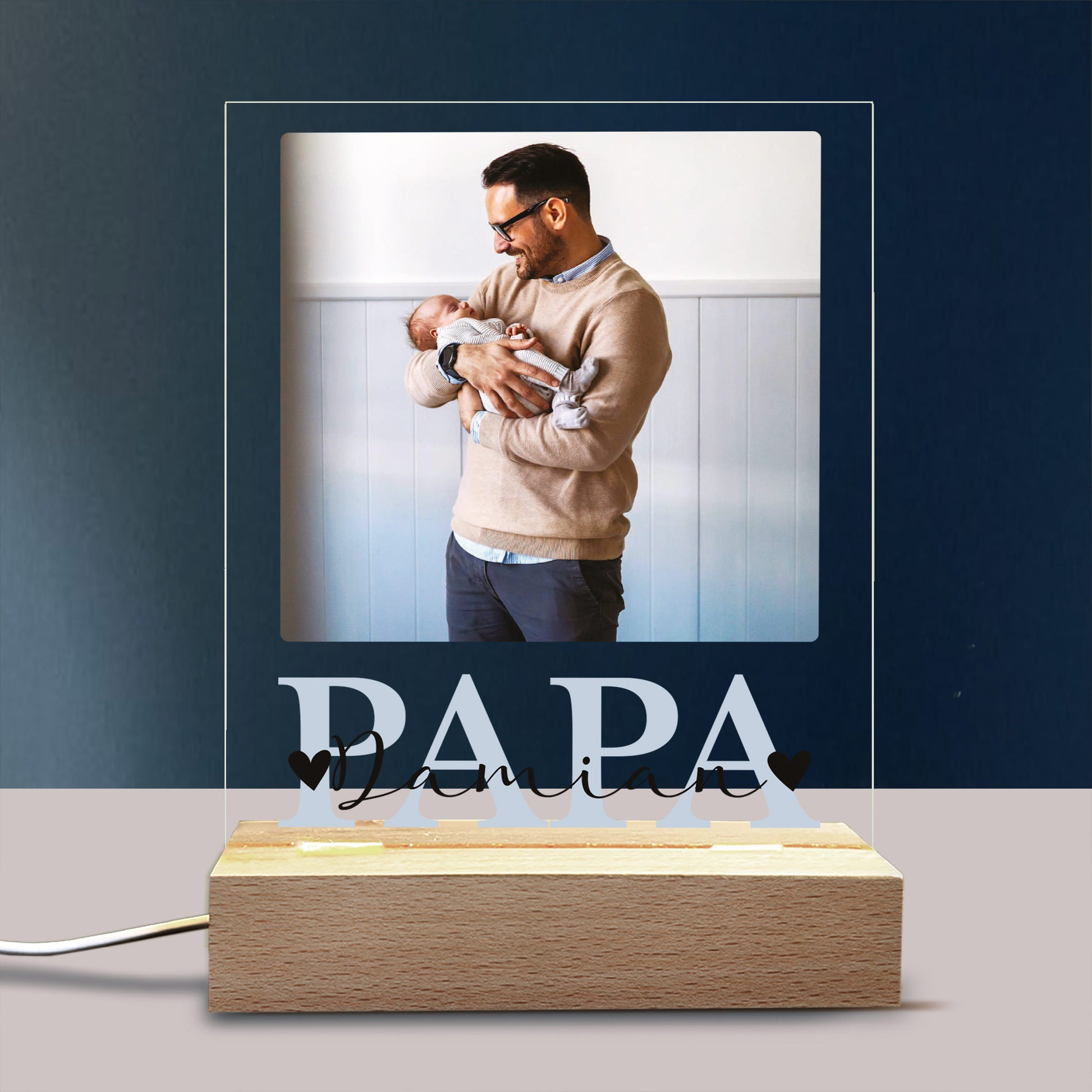 Leuchtende „PAPA“-Lampe mit Foto dekorativ auf Regal oder Nachttisch arrangiert.