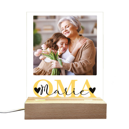 Personalisierte LED-Lampe mit „OMA“-Motiv und Holzsockel, freigestellt auf weißem Hintergrund.