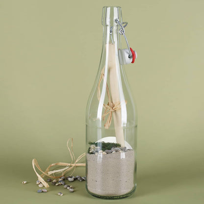 Gefüllte Flaschenpost mit Sand, Muscheln, Grün und Papier von hinten