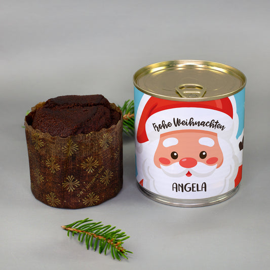 Personalisierter Weihnachts-Dosenkuchen mit Wunschname und ausgepacktem Brownie neben Tannenzweig als festliches Geschenk