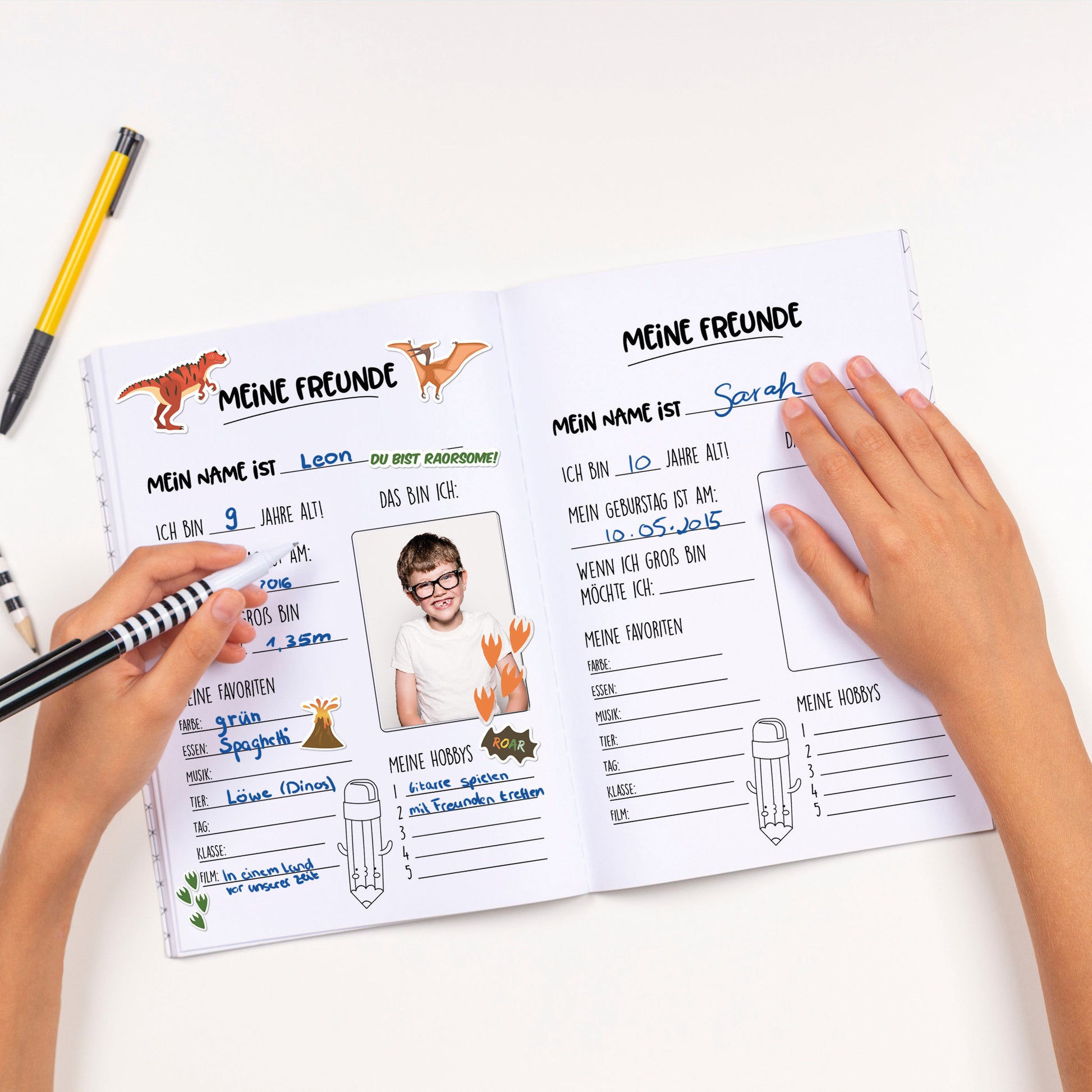 Aufgeschlagenes Freundebuch mit Dino-Stickern und persönlichem Foto