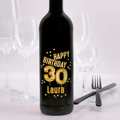 Weinflasche mit schwarzem Etikett „Happy Birthday 30 Laura“ in goldener Ballon-Optik, goldene Konfetti als Verzierung