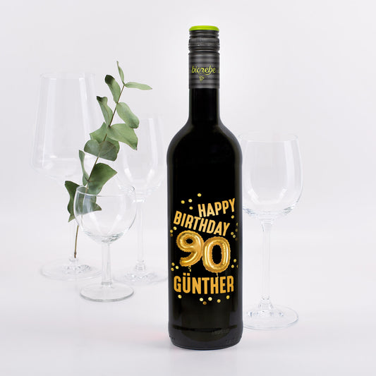 Rotweinflasche mit goldenem „Happy Birthday 90 Günther“-Aufdruck und Ballon-Design, dekoriert mit Gläsern und Eukalyptus