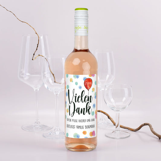 Personalisierter Roséwein mit Punkte-Etikett und Danke-Aufdruck für Susanne, aufgedeckter Tisch mit Gläsern