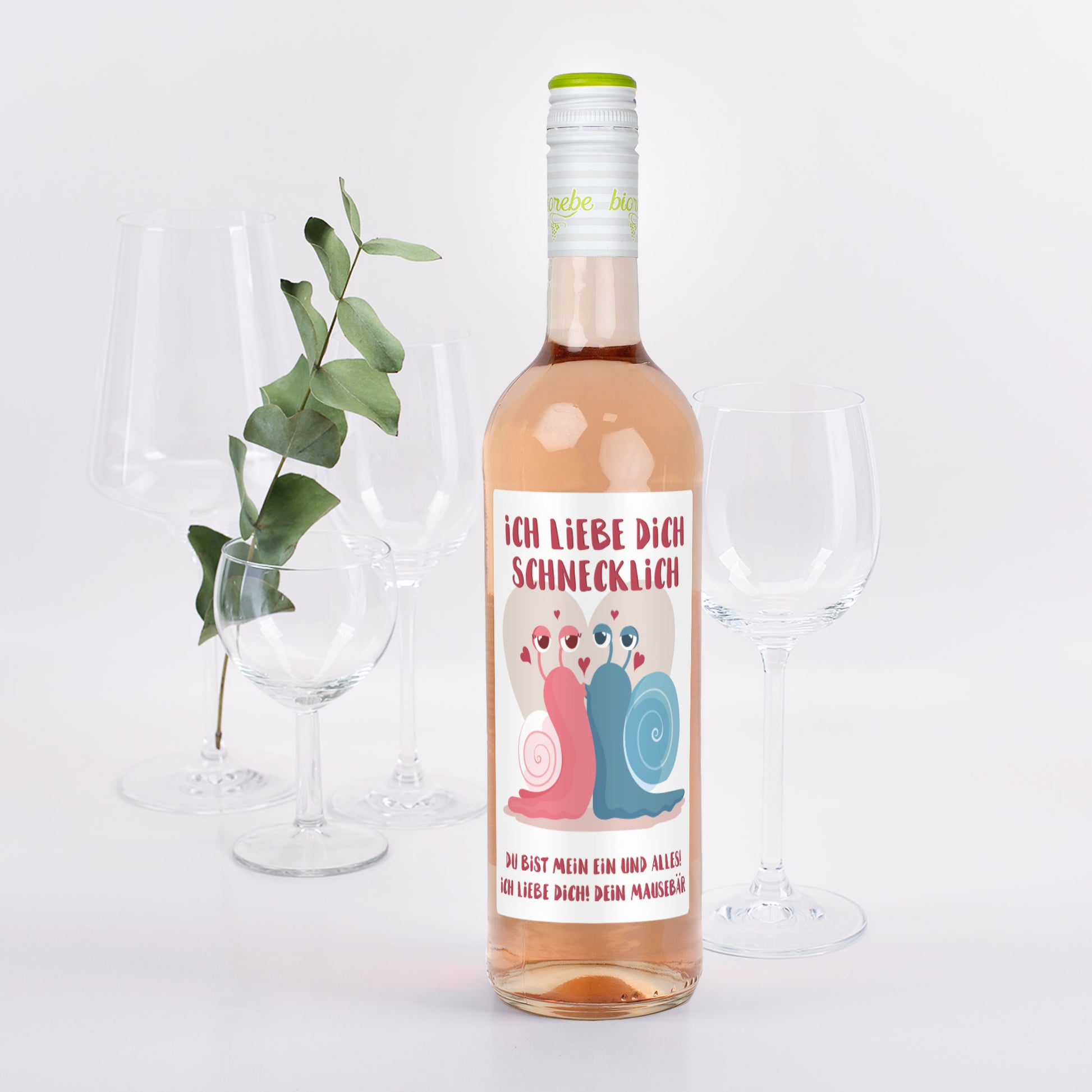 Roséweinflasche mit Etikett „Ich liebe dich schnecklich“, zwei bunte Schnecken mit Herzchen und Widmungstext