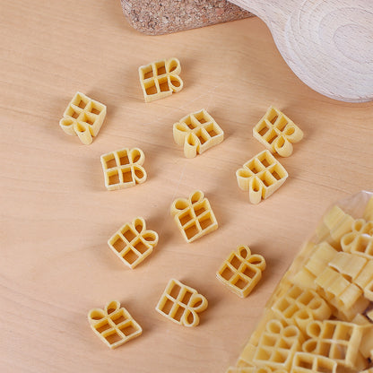 Nahaufnahme von Nudeln in Geschenkform – detailreich auf Holzoberfläche arrangiert