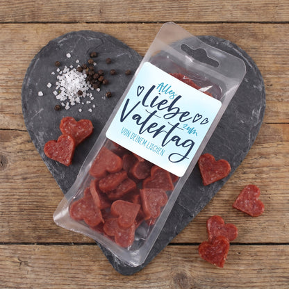 Männerpralinen mit Salami Herzen und personalisiertem Vatertagsetikett auf Schieferplatte mit Gewürzen
