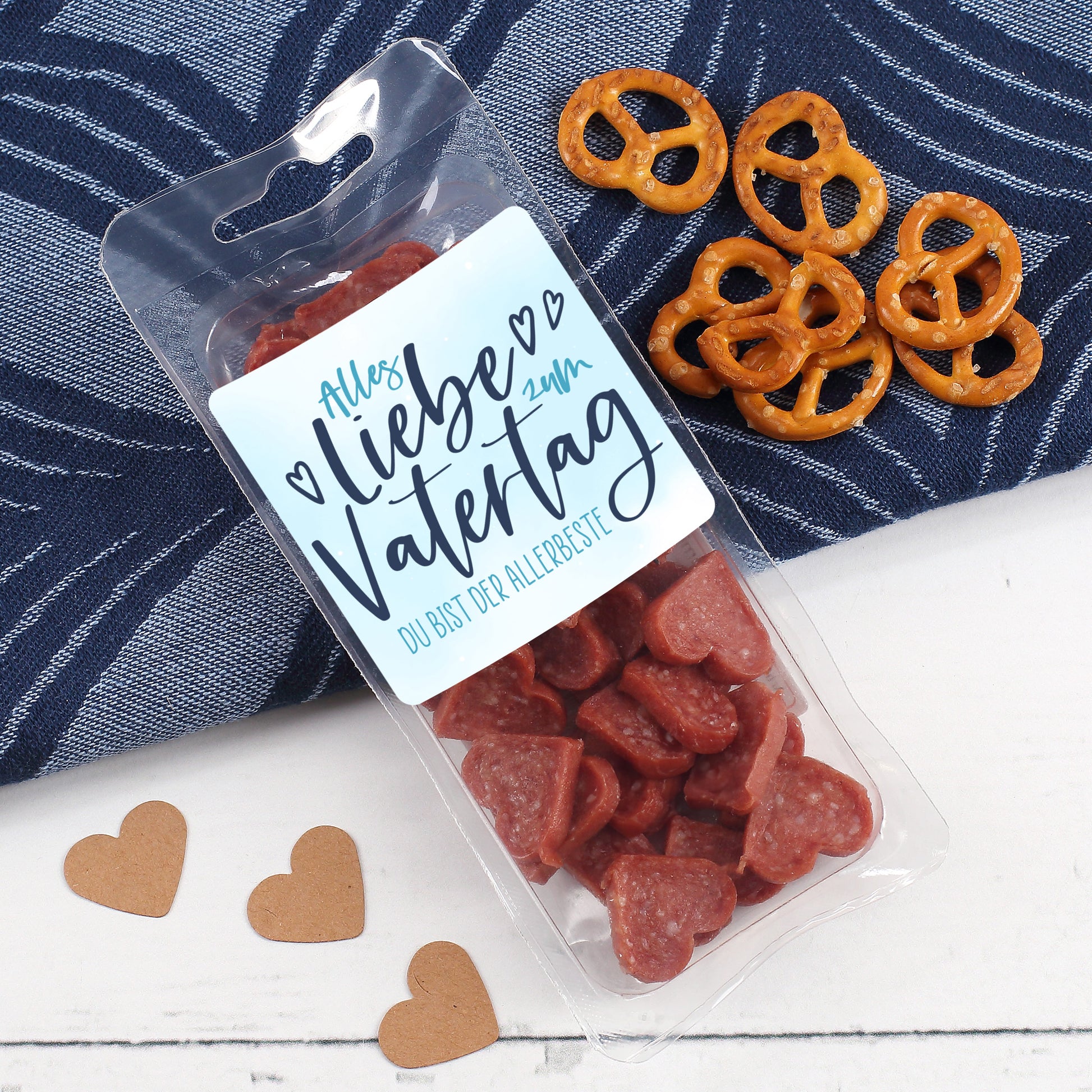 Salami Herzen in Verpackung mit Vatertagsdesign neben Snacks und Dekoration