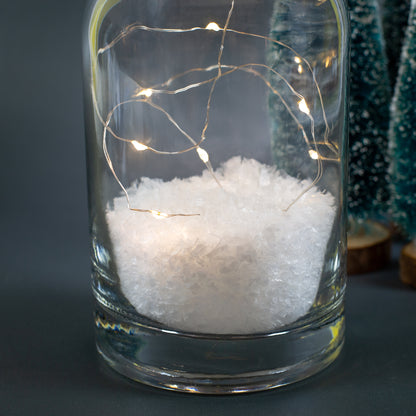 Nahaufnahme der LED-Lichterkette und des Kunstschnees im Inneren der dekorativen Weihnachtskaraffe.