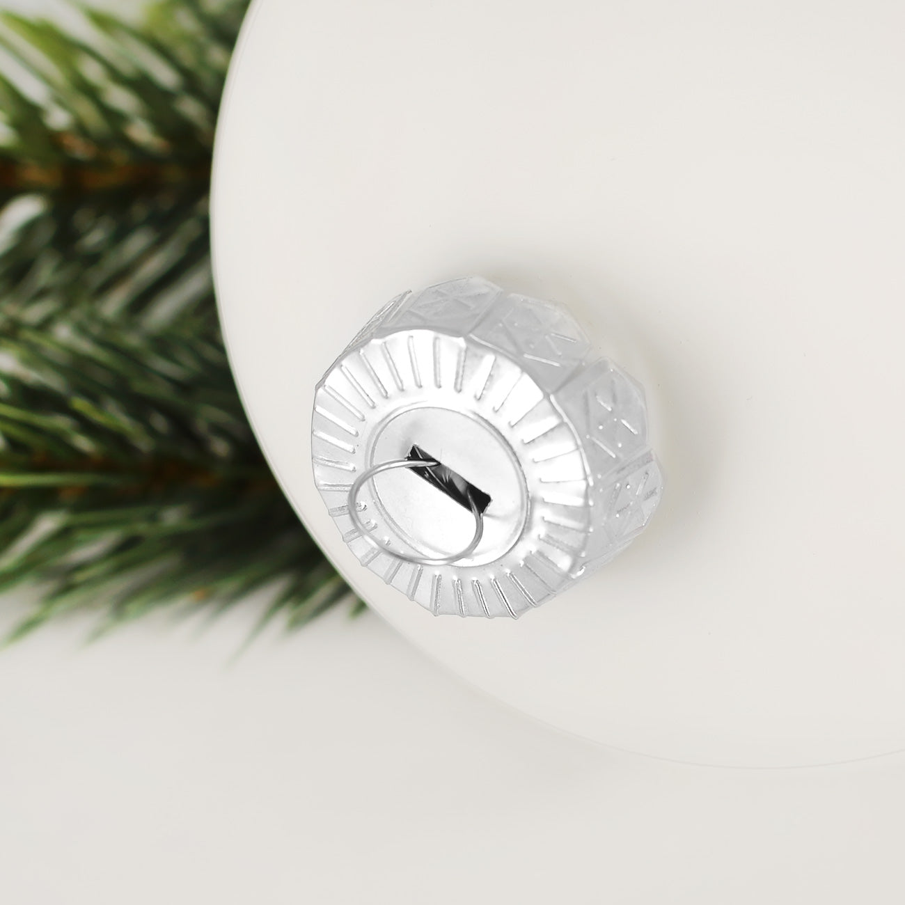 Detailfoto der weißen glänzenden Weihnachtskugel mit silberner Aufhängung