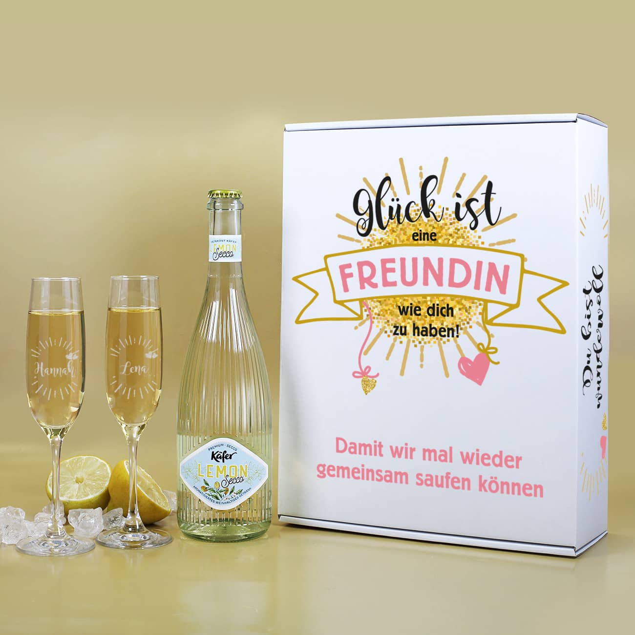 Geschenkset bestehend aus Papp-Geschenkverpackung  bedruckt mit einem niedlichen Motiv, Sektgläsern im 2er-Set mit persönlicher Gravur und eine Fruchtsecco mit Lemon Geschmack