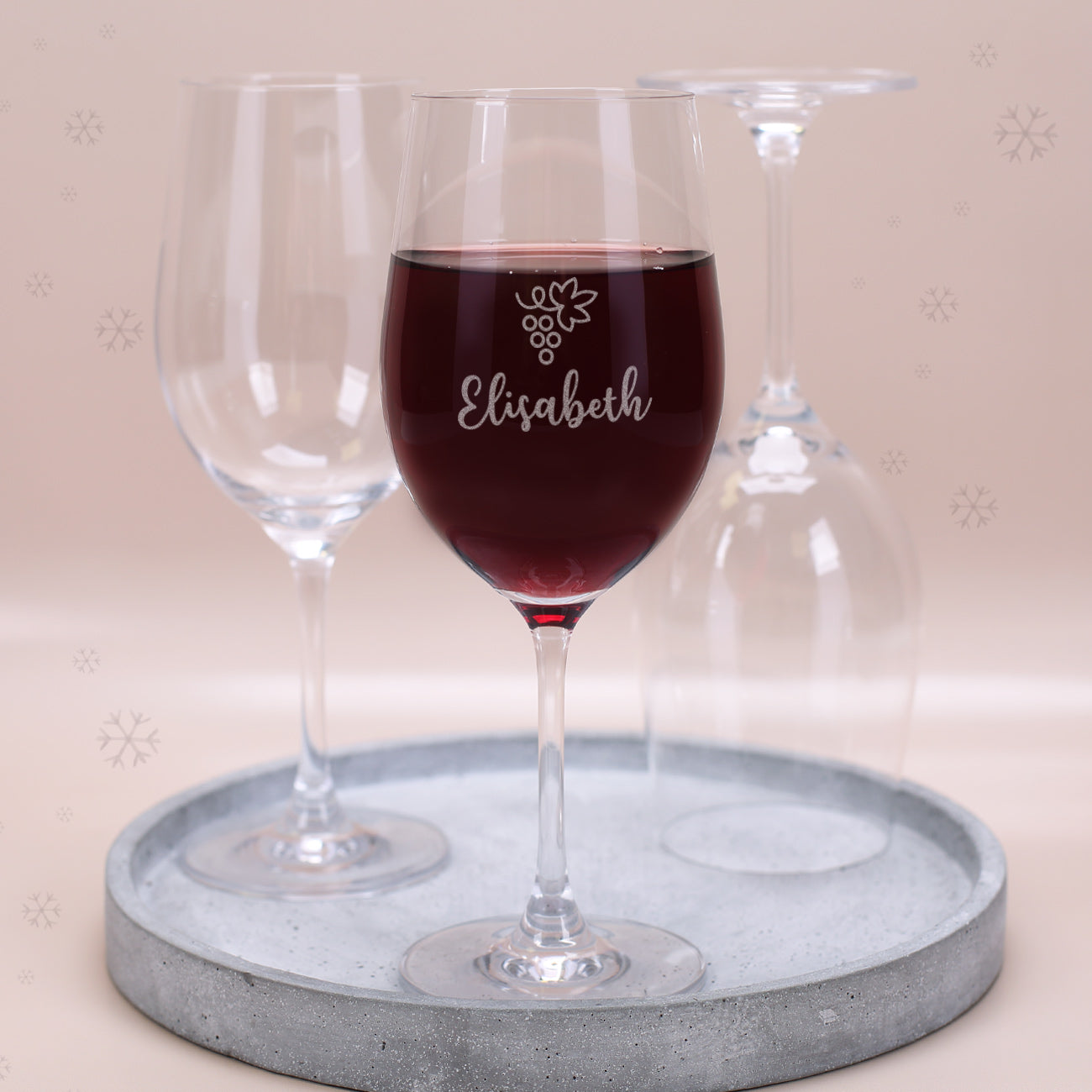 Leonardo Weinglas mit Gravur Motiv Traube und Name Elisabeth, gefüllt mit Rotwein auf Tablett mit weiteren Gläsern