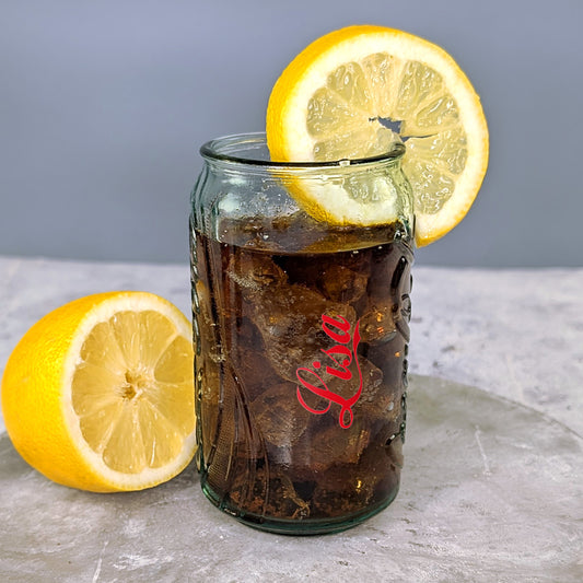 Glas gefüllt mit Cola, Zitronen und Eiswürfeln – Vintage-Design perfekt in Szene gesetzt