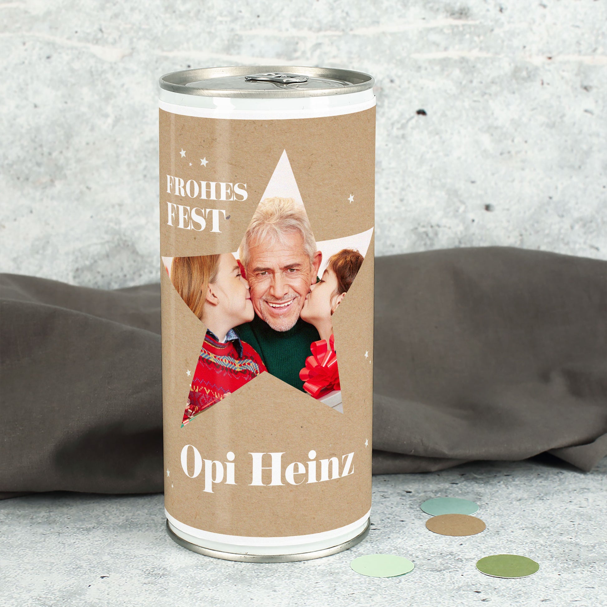 Weihnachtsbierdose mit großem Stern-Ausschnitt und eingedrucktem Familienfoto sowie Name „Opi Heinz“, winterliche Deko im Hintergrund.