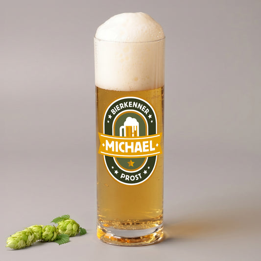 Personalisiertes Kölschglas mit Bierkenner Motiv und Name Michael, gefüllt mit Bier und Schaum, daneben Hopfen