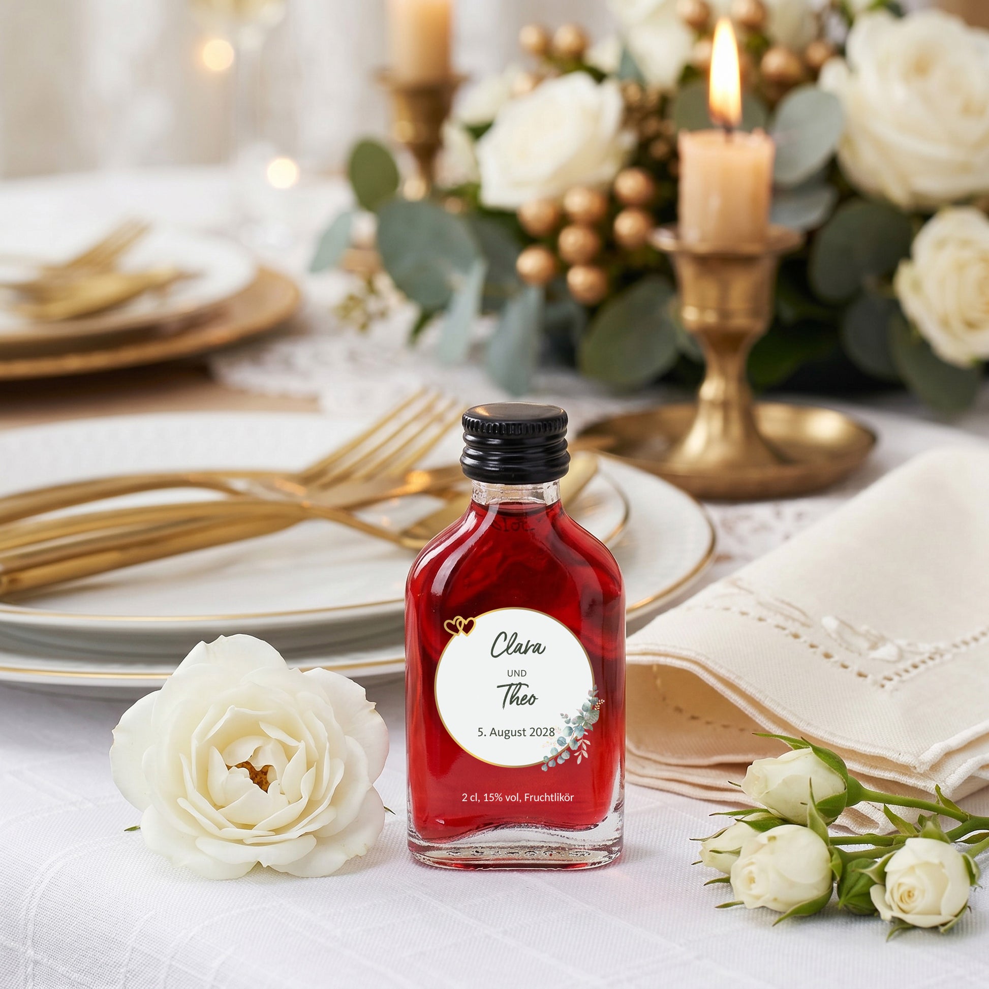 Personalisierter Fruchtlikör mit Namen Clara und Theo und Datum 5. August 2028 zwischen weißen Rosen und Hochzeitsdeko