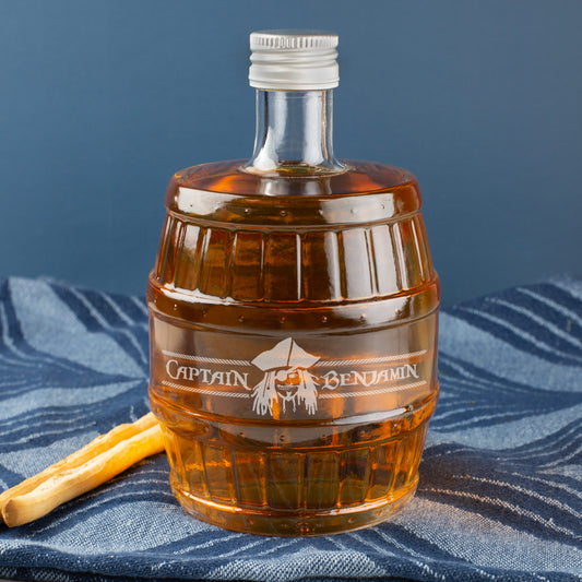 Whiskyflasche in Fassform mit Gravur „Captain Benjamin“ und Piratenkopf auf dunklem Hintergrund – personalisiert