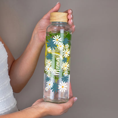 Personalisierte 600 ml Trinkflasche aus recyceltem Glas mit Name Mama und floralem Motiv in der Hand