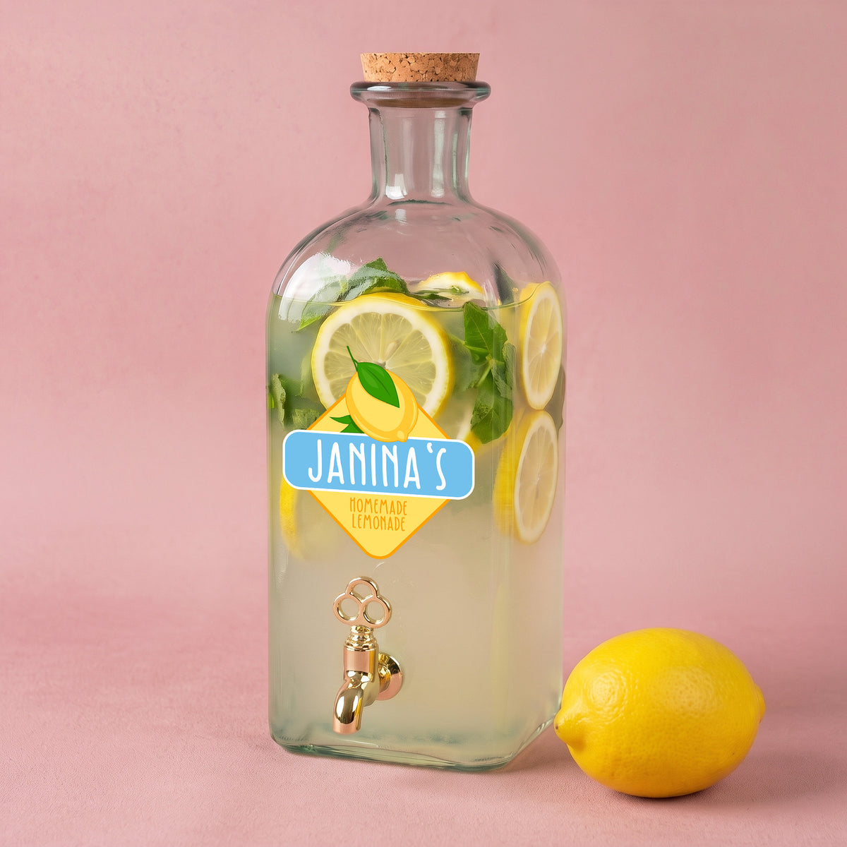 Personalisierter Glas Getränkespender mit Zitronen-Motiv, Name Janinas und gefüllter Limonade mit Zitronenscheiben und Minze