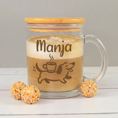 Glastasse mit Bambusdeckel und Namen Manja, gefüllt mit Kaffee und Milchschaum