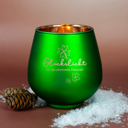 Grünes Windlicht mit Gravur „Glückslicht für die allerbeste Freundin“, dekoriert mit Zapfen und Kunstschnee