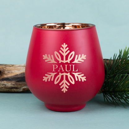 Rotes Windlicht mit gravierter Schneeflocke und dem Namen „Paul“, kupferfarbene Innenbeschichtung, weihnachtlich mit Tannenzweig dekoriert.