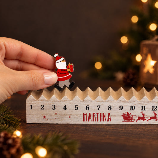 Detailansicht des Adventskalenders mit Name Wunschname während die bewegliche Weihnachtsmann-Figur auf der Holzleiste versetzt wird
