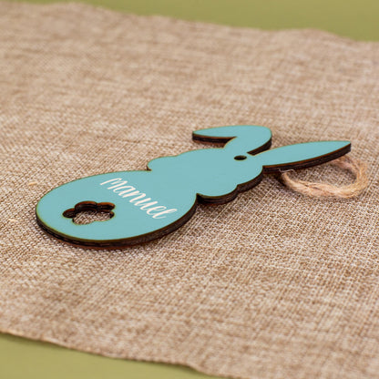 Personalisierter Holzanhänger in Hasenform in Blau mit Juteband, bedruckt mit dem Namen