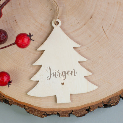 Holzanhänger in Tannenbaumform mit Gravur „Jürgen“ und kleinem Herzmotiv, dekoriert mit roten Beeren.