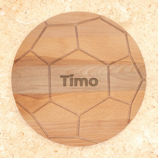 Rundes Holzbrett im Fußball-Look mit Gravur Timo auf hellem Untergrund