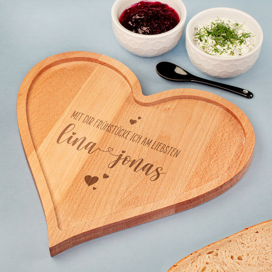 Personalisiertes Frühstücksbrettchen aus Holz in Herzform mit Gravur und Spruch, mit erhöhtem Rand, dekoriert mit Marmelade, Frischkäse und Brot