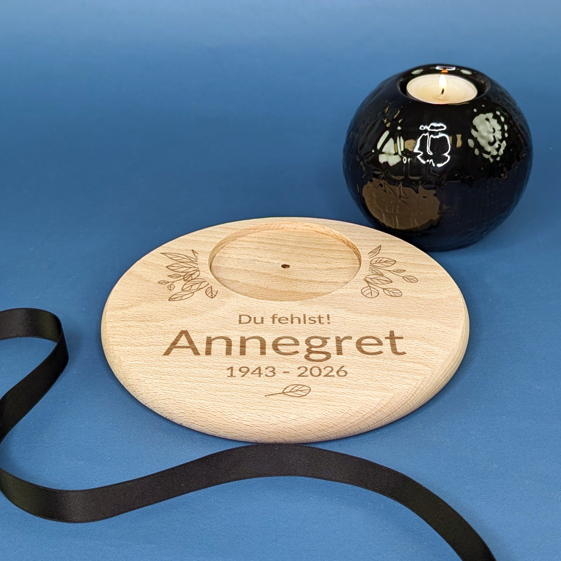 Kerzenteller zur Trauer mit Blattgravur – Name Josef, Lebensdaten und weißer Kerze, nah aufgenommen