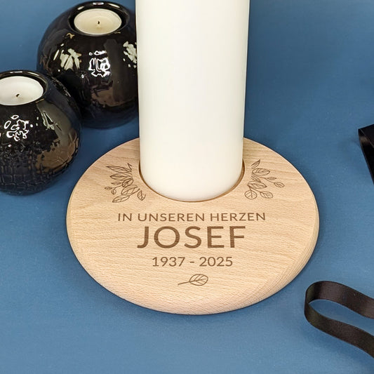 Detailaufnahme eines gravierten Holz-Kerzentellers zur Erinnerung mit weißer Kerze und Textgravur