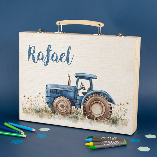 Holz-Malkoffer mit Traktormotiv und personalisiertem Namen auf blauem Hintergrund, Vorderansicht