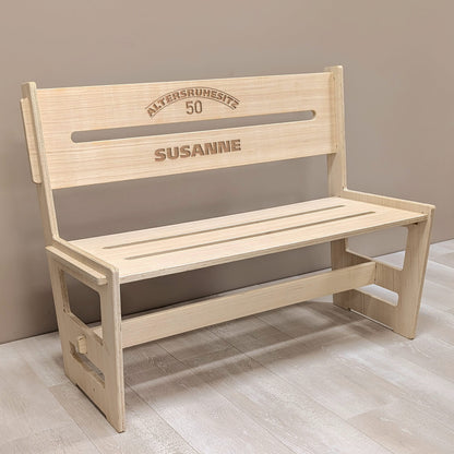 Personalisierte Holzbank für den Ruhestand mit Gravur „Altersruhesitz 50 SUSANNE“ in Innenraumkulisse