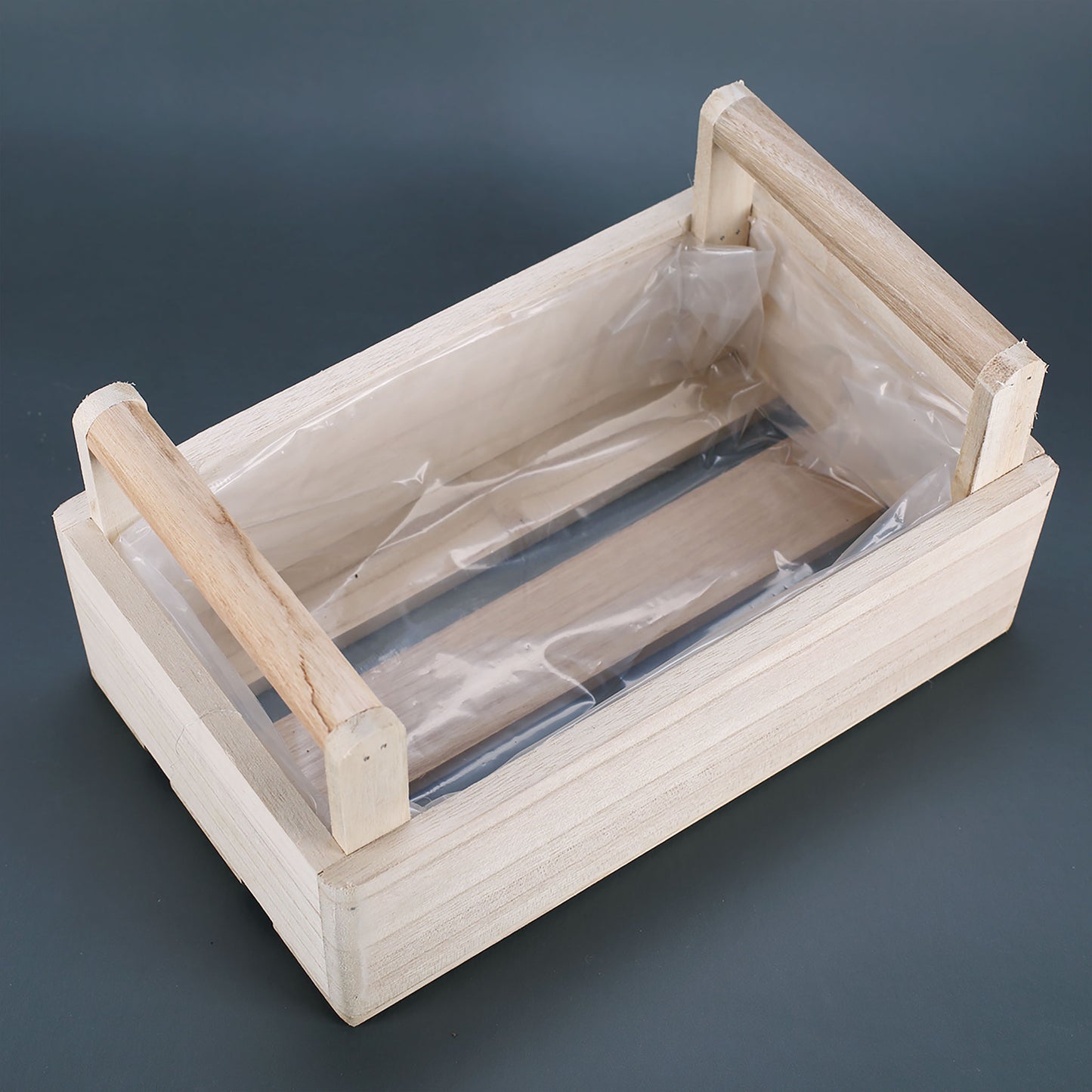 Pflanzkiste aus Holz mit zwei Griffen in Draufsicht, Innenraum mit Schutzfolie ausgelegt