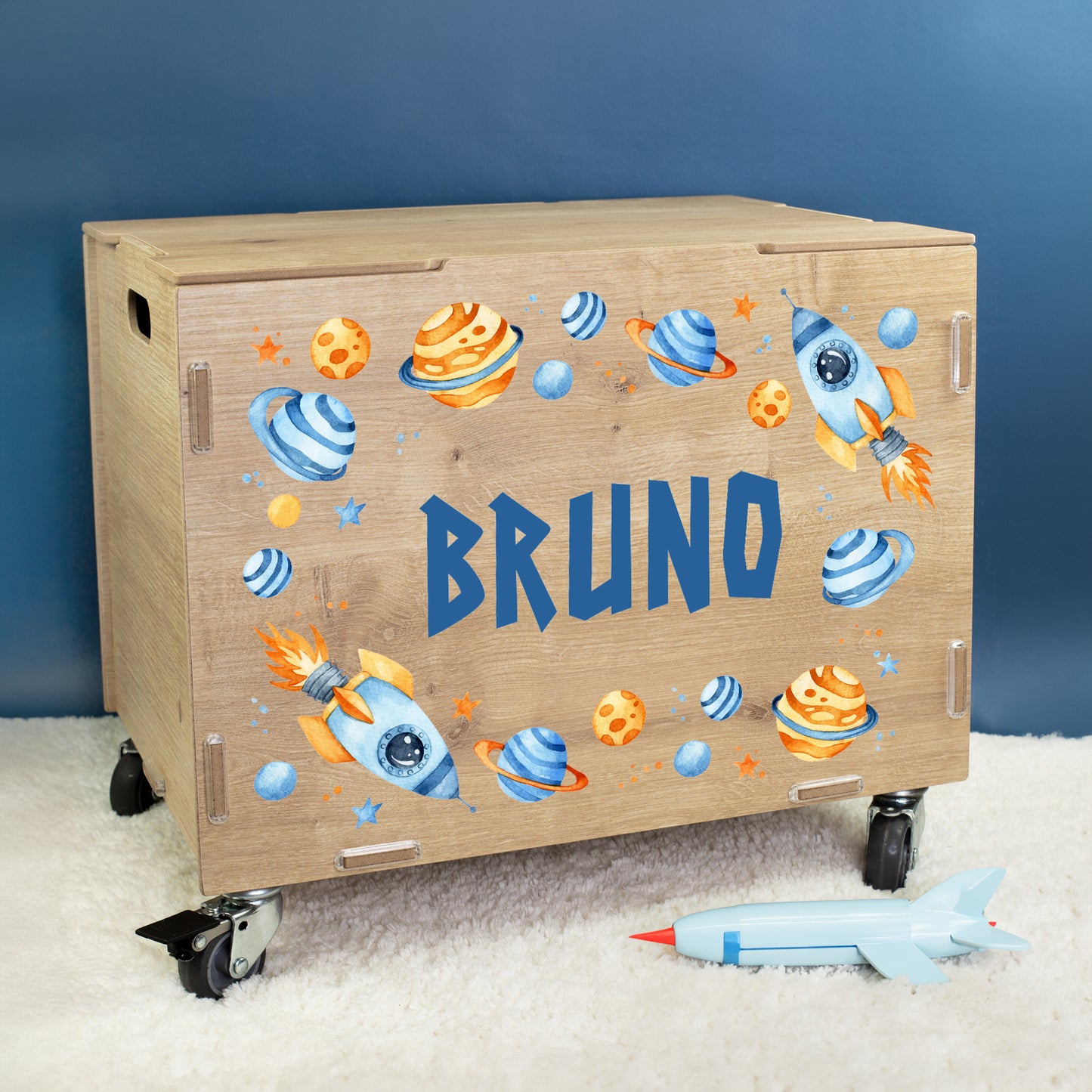 Personalisierte Rollkiste aus Holz mit Weltraum-Motiv für Jungen, bedruckt mit Raketen, Planeten und dem Namen Bruno auf der Vorderseite