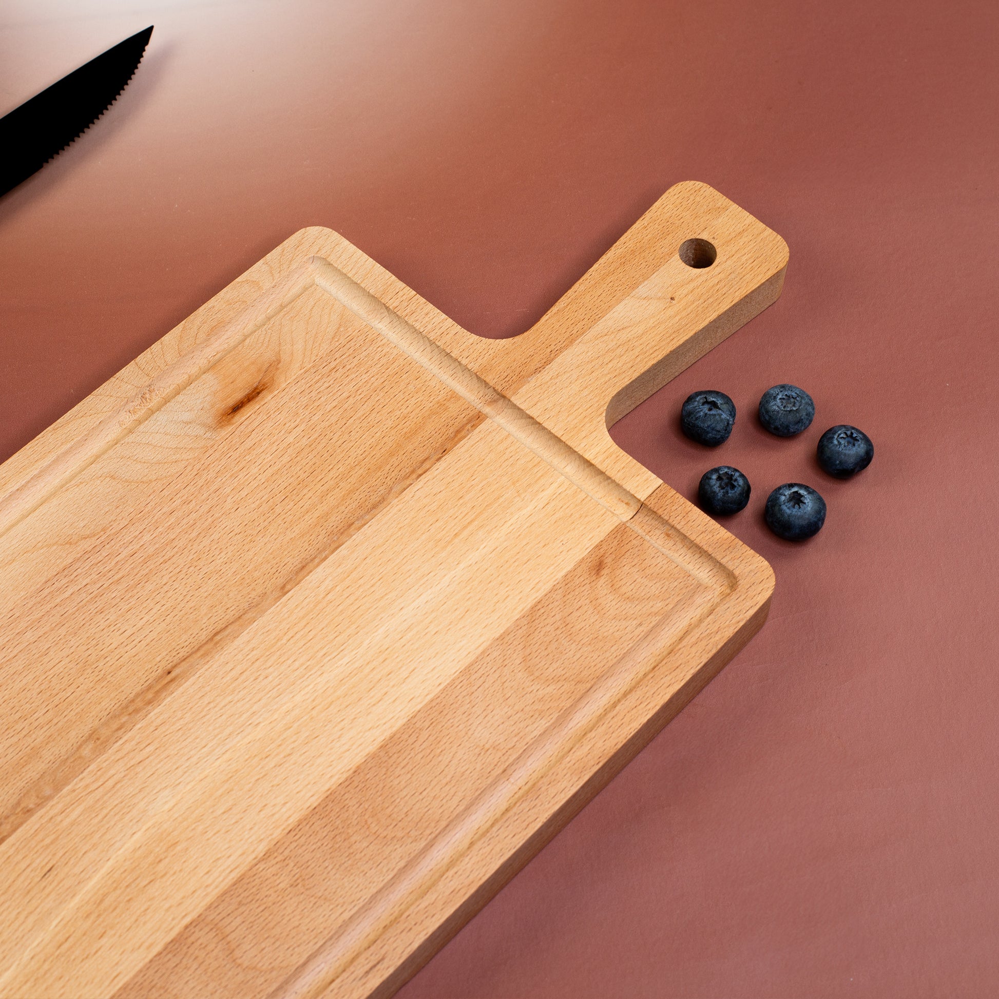 Detailfoto der Ablaufrinne und Griffzone des Servierbretts aus Buchenholz