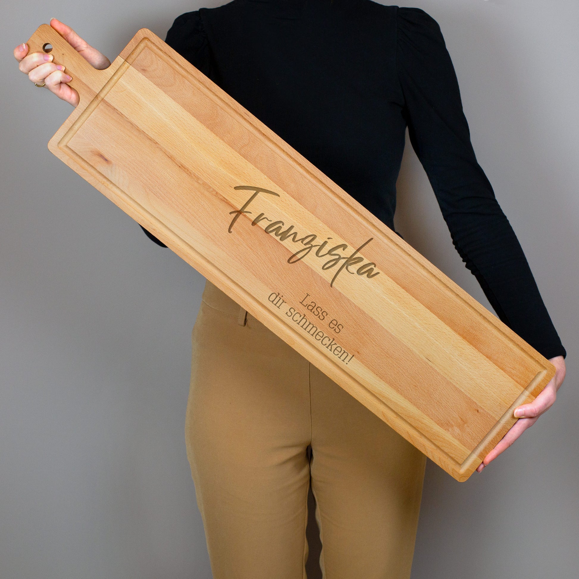 Person hält XXL-Servierbrett aus gedämpftem Buchenholz mit personalisierter Gravur Name und Wunschtext