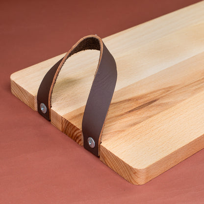 Detailaufnahme des Ledergriffs am Servierbrett aus gedämpftem Buchenholz.